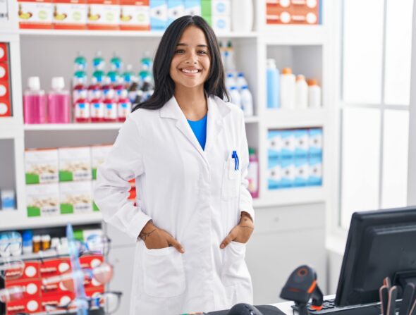 Young,Hispanic,Woman,Pharmacist,Smiling,Confident,Standing,At,Pharmacy